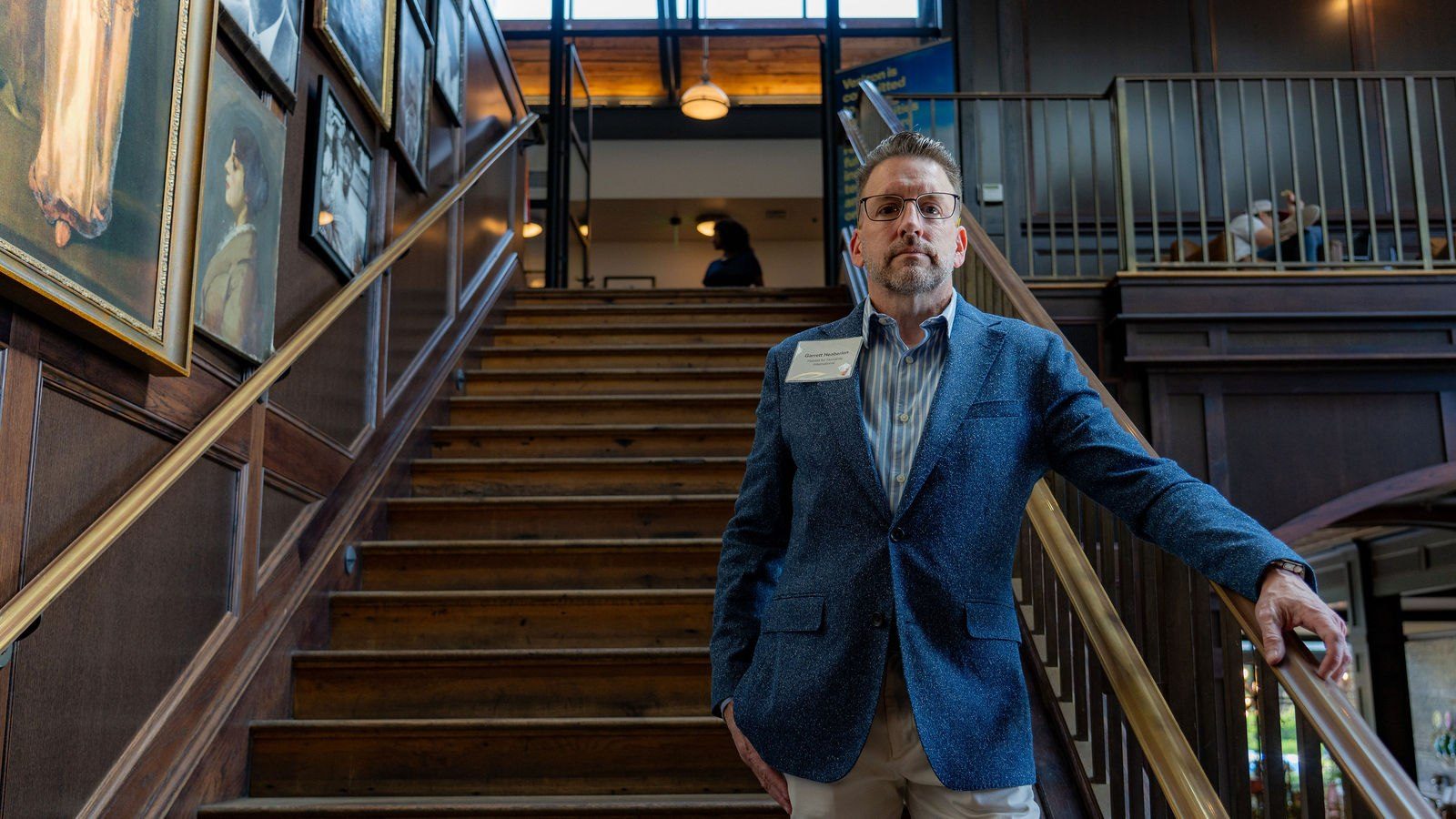 Guest portrait framed by the venue staircase and interior architecture
